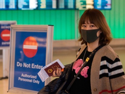 Passengers wear protective masks to protect against the spread of the Coronavirus as they