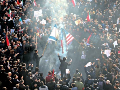 Iranians set a US and an Israeli flag on fire during a funeral procession organised to mou