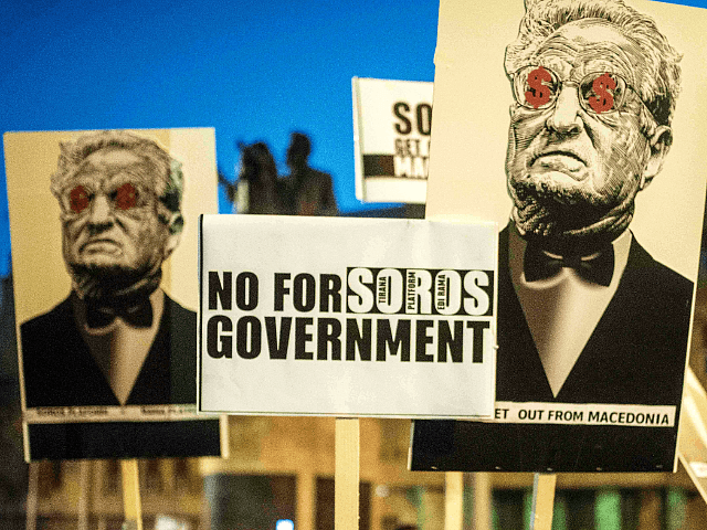 People hold anti-Soros banners during a demonstration against a deal …
