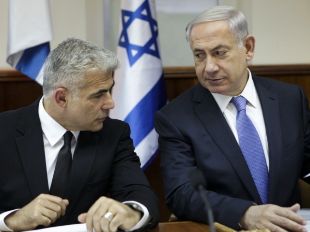Israeli Prime Minister Benjamin Netanyahu (R) speaks with Finance Minister Yair Lapid duri