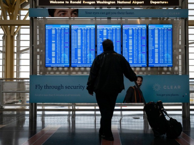 ARLINGTON, VA - NOVEMBER 27: A passenger looks at the departures board at Ronald Reagan National Airport on the day before the Thanksgiving holiday, November 27, 2019 in Arlington, Virginia. Both the American West and Midwest are facing significant weather events that could impact travelers. (Photo by Drew Angerer/Getty Images)