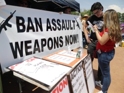 EL PASO, TEXAS - AUGUST 07: A 'Ban Assault Weapons Now' sign is displayed near a voter registration table at a protest against President Trump's visit, following a mass shooting which left at least 22 people dead, on August 7, 2019 in El Paso, Texas. Protestors also called for gun …