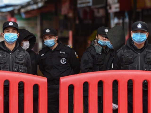 A police officers and security guards stand outside the Huanan Seafood Wholesale Market wh