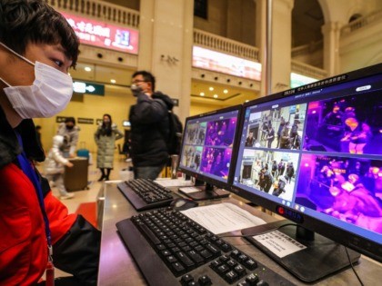 TOPSHOT - A staff member screens arriving passengers with thermal scanners at Hankou railway station in Wuhan, in China's central Hubei province on January 21, 2020. - Asian countries on January 21 ramped up measures to block the spread of a new virus as the death toll in China rose …