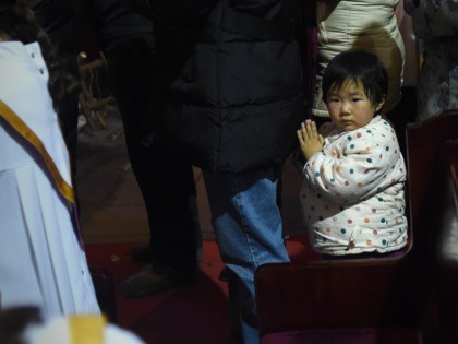 A young Chinese worshipper attends the Christmas Eve mass at a Catholic church in Beijing on December 25, 2014 as Christians around the world prepare to celebrate the holy day. / AFP / WANG ZHAO (Photo credit should read WANG ZHAO/AFP via Getty Images)