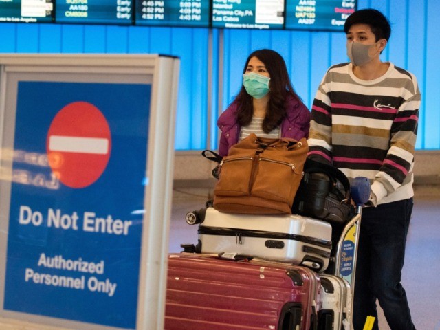 Passengers wear protective masks to protect against the spread of the Coronavirus as they arrive at the Los Angeles International Airport, California, on January 22, 2020. - A new virus that has killed nine people, infected hundreds and has already reached the US could mutate and spread, China warned on …