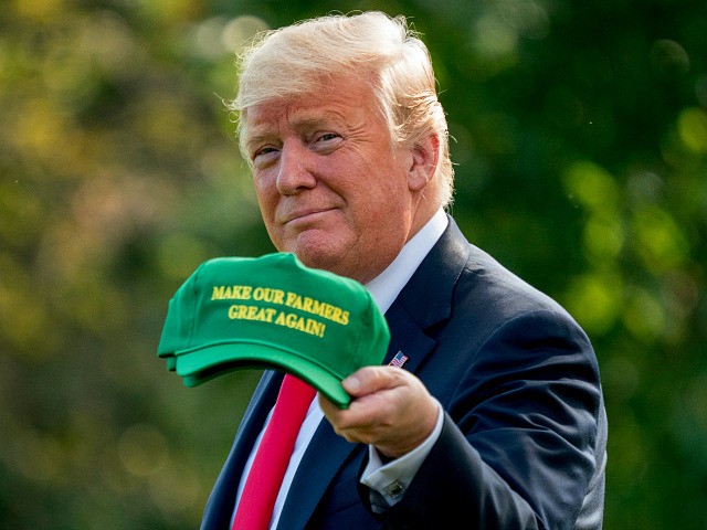 President Donald Trump hold up hats that read "Make Our Farmers Great Again!" as he walks across the South Lawn before boarding Marine One at the White House in Washington, Thursday, Aug. 30, 2018, for a short trip to Andrews Air Force Base, Md., and then on to Evansville, Ind., …