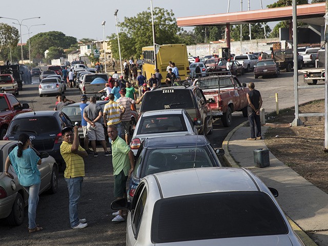 People line the street with their vehicles as they wait to fill up with gas at a fuel station, top right, in Cabimas, Venezuela, Wednesday, May 15, 2019. U.S. sanctions on oil-rich Venezuela appear to be taking hold, resulting in mile-long lines for fuel in the South American nation’s second-largest …