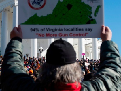 A pro gun supporter holds a sign during a protest march on the grounds of the Virginia State Capitol in Richmond, Virginia on January 20, 2020. - Several thousand gun rights supporters massed near the Virginia state capitol Monday for a rally under heavy surveillance and a state of emergency …