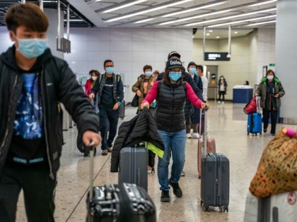 HONG KONG, CHINA - JANUARY 29: Travellers wearing protective masks exit the arrival hall at Hong Kong High Speed Rail Station on January 29, 2020 in Hong Kong, China. Hong Kong government will deny entry for travellers who has been to Hubei province except for local residents in response to …