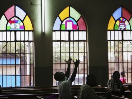 KANO, KANO - APRIL 12: A Nigerian Catholic worshipper prays during morning mass April 12, 2005 in Kano, Nigeria. Kano is part of Nigeria's primarily Muslim north, but devoted Catholic minority participates in frequent Masses in local cathedrals. Cardinal Francis Arinze of Nigeria is considered a leading contender to become …