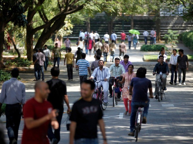 FILE- In this Jan. 11, 2013 file photo, Infosys Technologies employees move through the headquarters during a break in Bangalore, India. The shares of top Indian IT companies are falling in response to news of proposed U.S. legislation that would require salaries for H-1B visa holders to be doubled to …