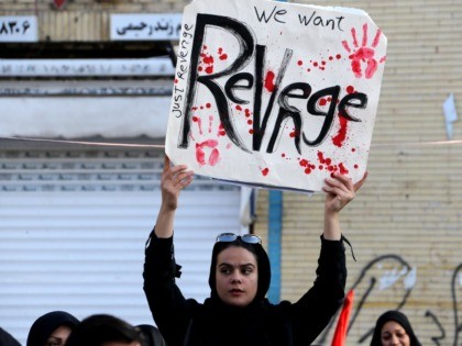 An Iranian mourner holds a placard during the final stage of funeral processions for slain