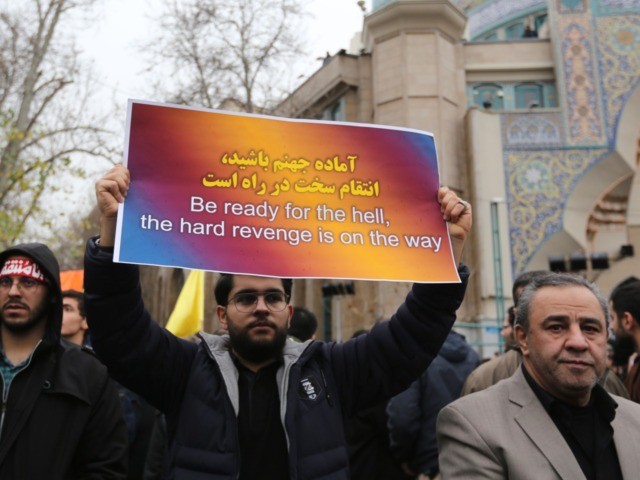 Iranians raise a placard during an anti-US rally to protest the killings during a US air s