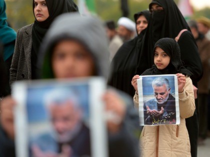 TOPSHOT - Protesters carry posters with the image of top Iranian commander Qasem Soleimani