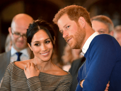 CARDIFF, WALES - JANUARY 18: Prince Harry whispers to Meghan Markle as they watch a dance