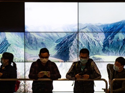 People wearing facemasks queue at the West Kowloon rail station in Hong Kong on January 23, 2020. - The international finance hub has been on high alert for the mystery SARS-like virus ever since it first emerged within the Chinese city of Wuhan, killing 17 people so far. (Photo by …