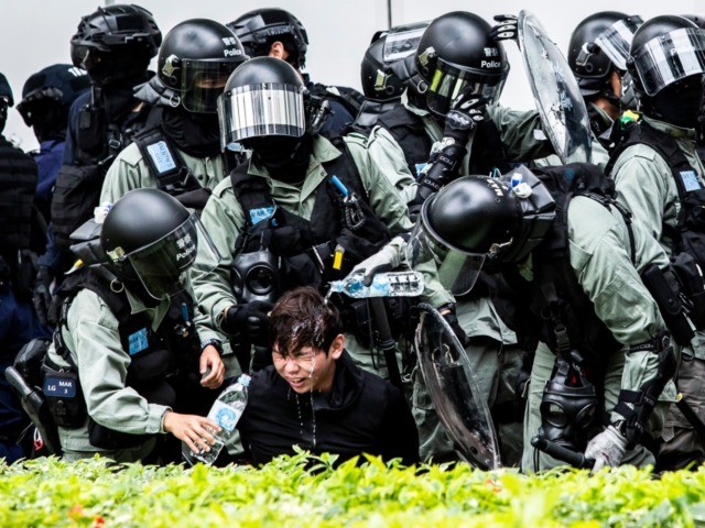 OPSHOT - A man (C) has pepper spray washed from his his face by police after being detaine