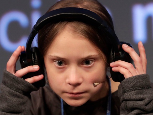 Climate activist Greta Thunberg adjusts the headphones during a press conference in Madrid
