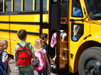 Elementary school students get on bus