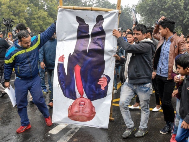 People hold a poster representing US President Donald Trump (C) to protest against the US
