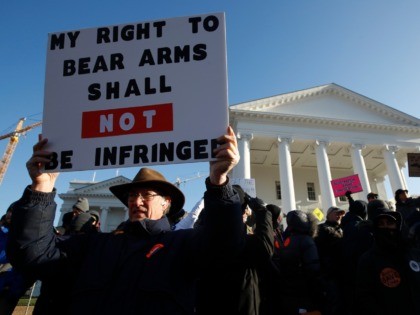 Billy Llewellyn, of Hanover Va., holds a sign in front of the Virginia State Capitol Monday, Jan. 20, 2020, in Richmond, Va. (AP Photo/Steve Helber)