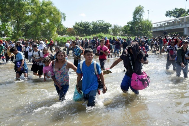 Troops fire gas as migrants try to storm into Mexico
