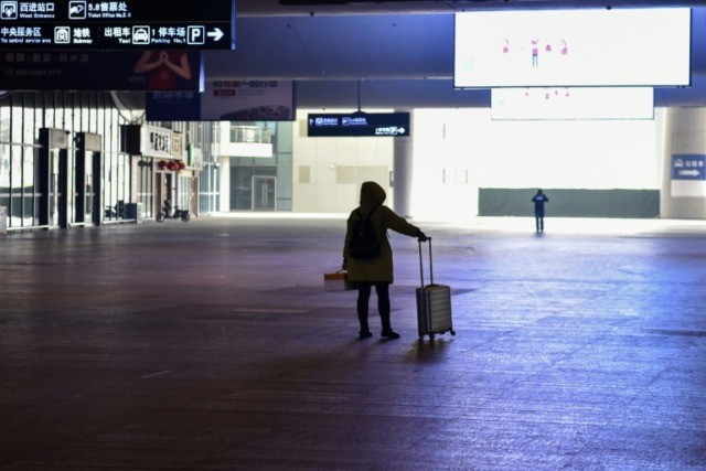A passenger stands in the arrivals hall at the near-deserted Wuhan train station 'End of the world': Wuhan residents react to quarantine