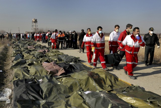 Iran Plane Crash In this Wednesday, Jan. 8, 2020 file photo, rescue workers carry the body of a victim of a Ukrainian plane crash in Shahedshahr, southwest of the capital Tehran, Iran. Two U.S. officials said Thursday that it was “highly likely” that an Iranian anti aircraft missile downed a Ukrainian jetliner late Tuesday, killing all 176 people on board. President Donald Trump is suggesting he believes Iran was responsible. (AP Photo/Ebrahim Noroozi, File) The Associated Press