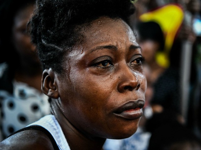 A woman cries during a family member's funeral organised by government opposition in Port-