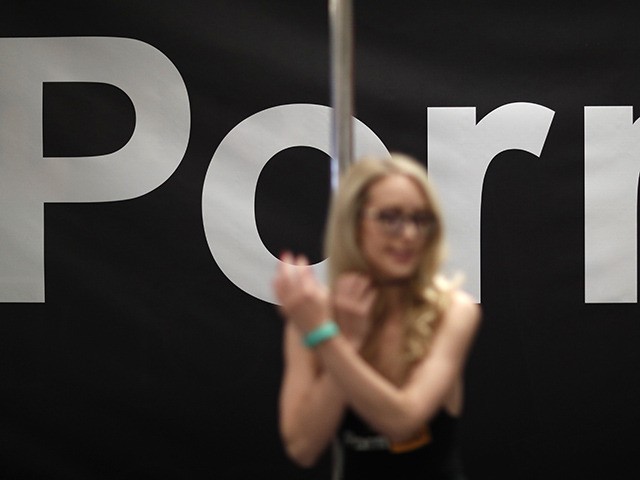 Porn actress Ginger Banks stands in the Pornhub booth during the AVN Adult Entertainment Expo, Wednesday, Jan. 24, 2018, in Las Vegas. (AP Photo/John Locher)