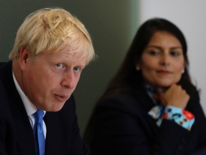 Britain's Prime Minister Boris Johnson speaks alongside Home Secretary Priti Patel during the first meeting of the National Policing Board at the Home Office in London, Wednesday, July 31, 2019. (AP Photo/Kirsty Wigglesworth, pool)