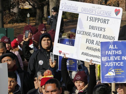 Demonstrators hold signs as they attend a rally supporting legislation calling for drivers