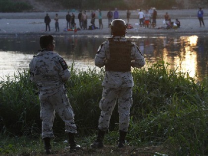 Mexican National Guards stand on the Mexican side of the Suchiate River near Ciudad Hidalgo, Mexico, where they watch Central American migrants standing on the Guatemalan side of the river, early Wednesday, Jan. 22, 2020. The number of migrants stuck at the Guatemala-Mexico border continued to dwindle Wednesday as detentions …