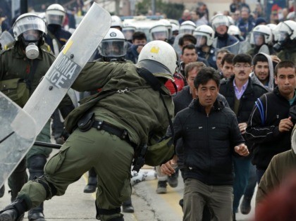 Riot police scuffle with migrants during a protest in Mytilene port on the northeastern Ae