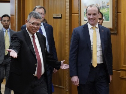 Malaysian Foreign Minister Saifuddin Abdullah, left, welcomes Britain's Foreign Secretary Dominic Raab at Foreign Ministry in Putrajaya, Malaysia, Tuesday, Feb. 11, 2020. (AP Photo/Vincent Thian)
