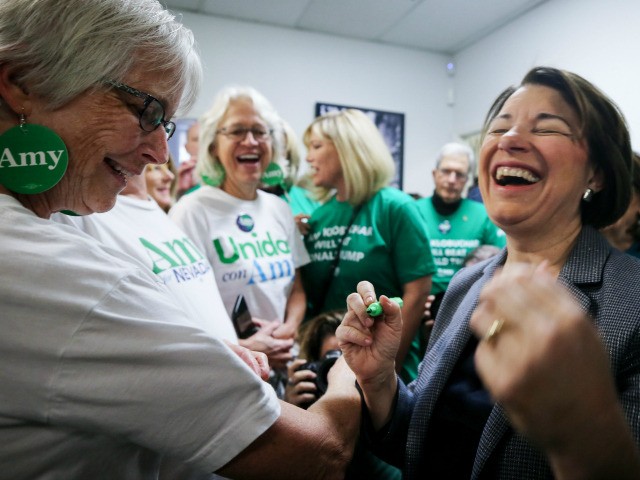 Democratic presidential candidate Sen. Amy Klobuchar (D-MN), R, laughs while she greets su