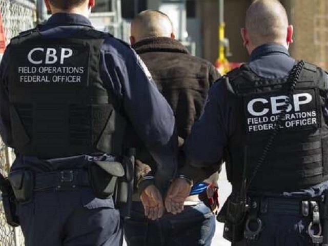 CBP Officers at the Laredo Port of Entry escort a wanted fugitive to detention. (Photo: U.S. Customs and Border Protection/Laredo Sector)