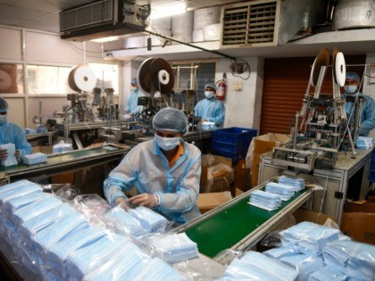 A worker packs protective facemasks at a production facility in the outskirts of Ahmedabad on February 3, 2020. - China said on February 3 it urgently needed medical equipment and surgical masks as the death toll from a new coronavirus jumped above 360, making it more deadly than the SARS …