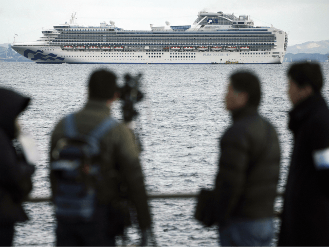 A TV crew film a cruise ship Diamond Princess anchoring off the Yokohama Port Tuesday, Feb