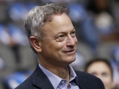 Actor Gary Sinise looks on before an NBA basketball game between the Washington Wizards and the Dallas Mavericks, Saturday, Dec. 12, 2015, in Dallas. (AP Photo/Jim Cowsert)