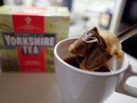 A man poses making a cup of tea with a Yorkshire Tea teabag with a box of tea in the background arranged as an illustration in London on December 19, 2018. - Britons are up in arms over new environmentally-friendly teabags that leave a bitter taste in the mouth as …