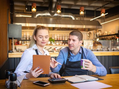 Young man and woman going through paperwork together in their restaurant. Small family res