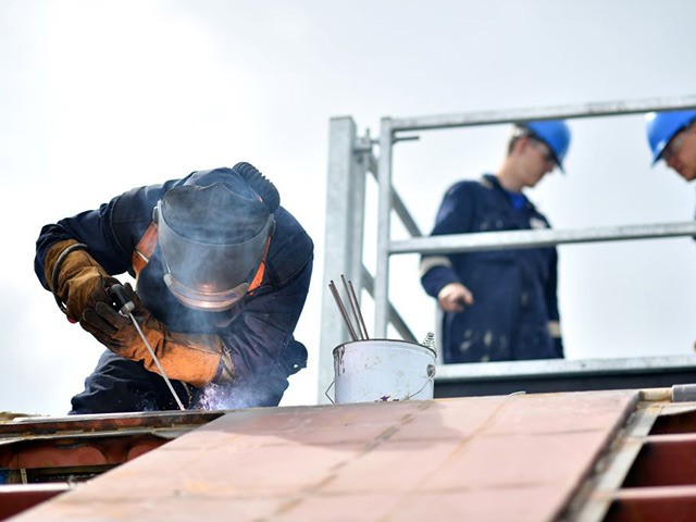 A welder works on a boat at Mainstay Marine Solutions' shipyard in Milford Haven in Wales