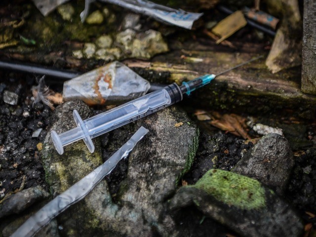 A picture shows discarded drug paraphenallia in a small wooded area used by addicts to take drugs near Glasgow city centre, Scotland, on August 15 2019. - Drug addict Michael arrives at a derelict scrap of land near Glasgow city centre littered with used syringes and other drug detritus to …