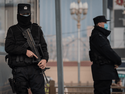 In this picture taken on January 27, 2020 police officers wearing protective facemasks to help stop the spread of a deadly virus which began in Wuhan, secure an area at the Beijing railway station. - The deadly new coronavirus that has broken out in China, 2019-nCoV, will afflict a minimum …