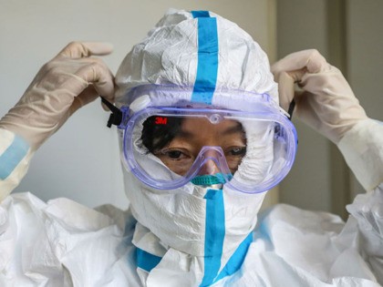 This photo taken on January 30, 2020 shows a doctor putting on a pair of protective glasses before entering the isolation ward at a hospital in Wuhan in China's central Hubei province, during the virus outbreak in the city. - The World Health Organization declared a global emergency over the …