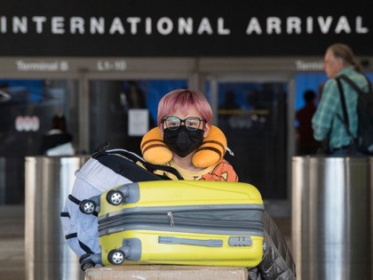 Passengers wear face masks to protect against the spread of the Coronavirus as they arrive