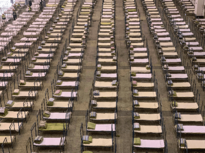 Workers set up beds at an exhibition centre that was converted into a hospital in Wuhan in