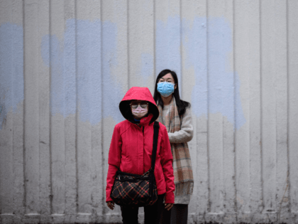 Pedestrians wear facemasks as they prepare to cross a road in Hong Kong on February 4, 2020, as a preventative measure following a virus outbreak which began in the Chinese city of Wuhan. - Hong Kong on February 4 became the second place outside mainland China to report the death …